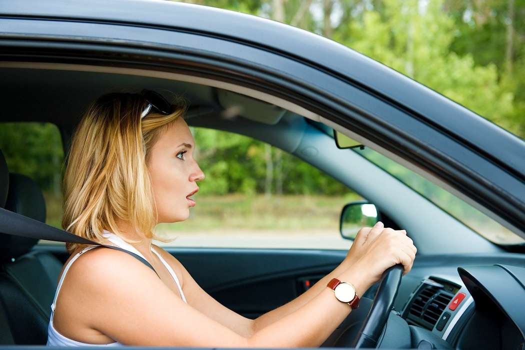 Женщина неуверенный водитель за рулем автомобиля