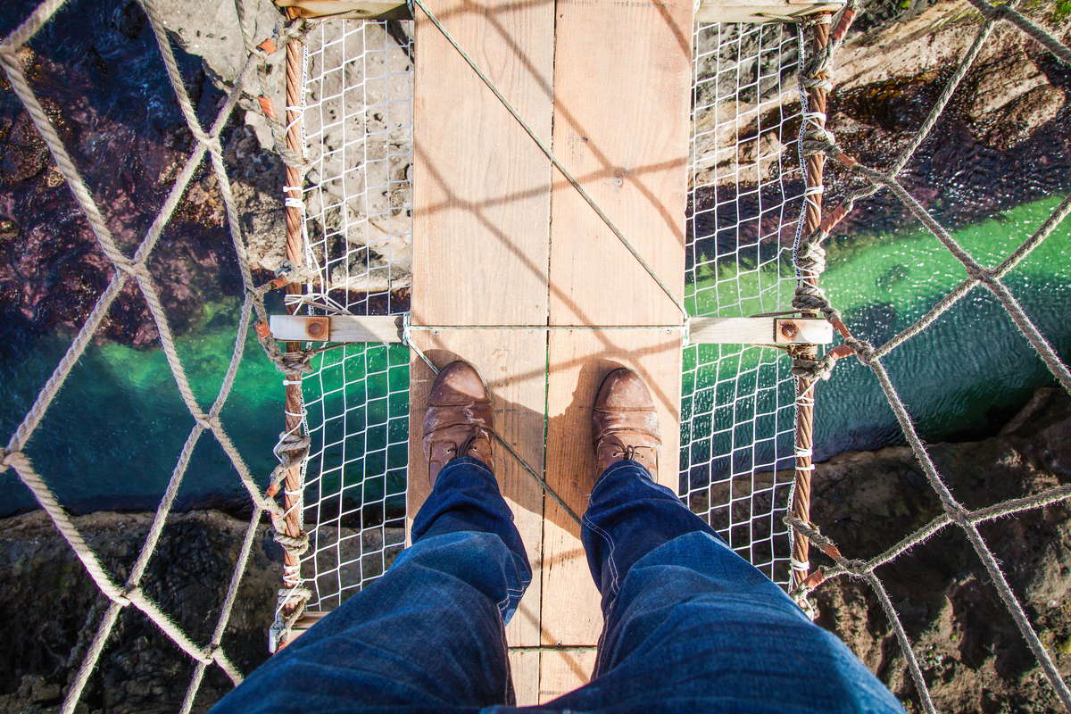 ноги человека стоящего на мосту смотрит вниз